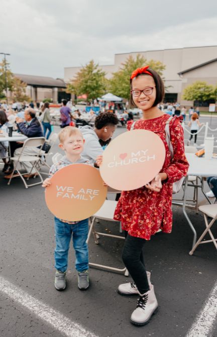Kids Two kids holding signs at an outdoor church event