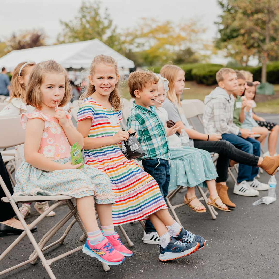 Kids sitting in chairs outdoors