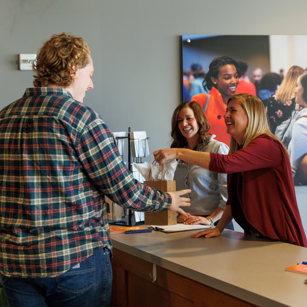 People being greeted at the new here table